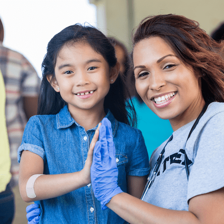Community Health clinician high fiving a child
