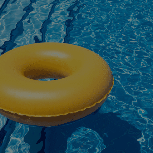 Pool with a yellow inflatable floating in it.